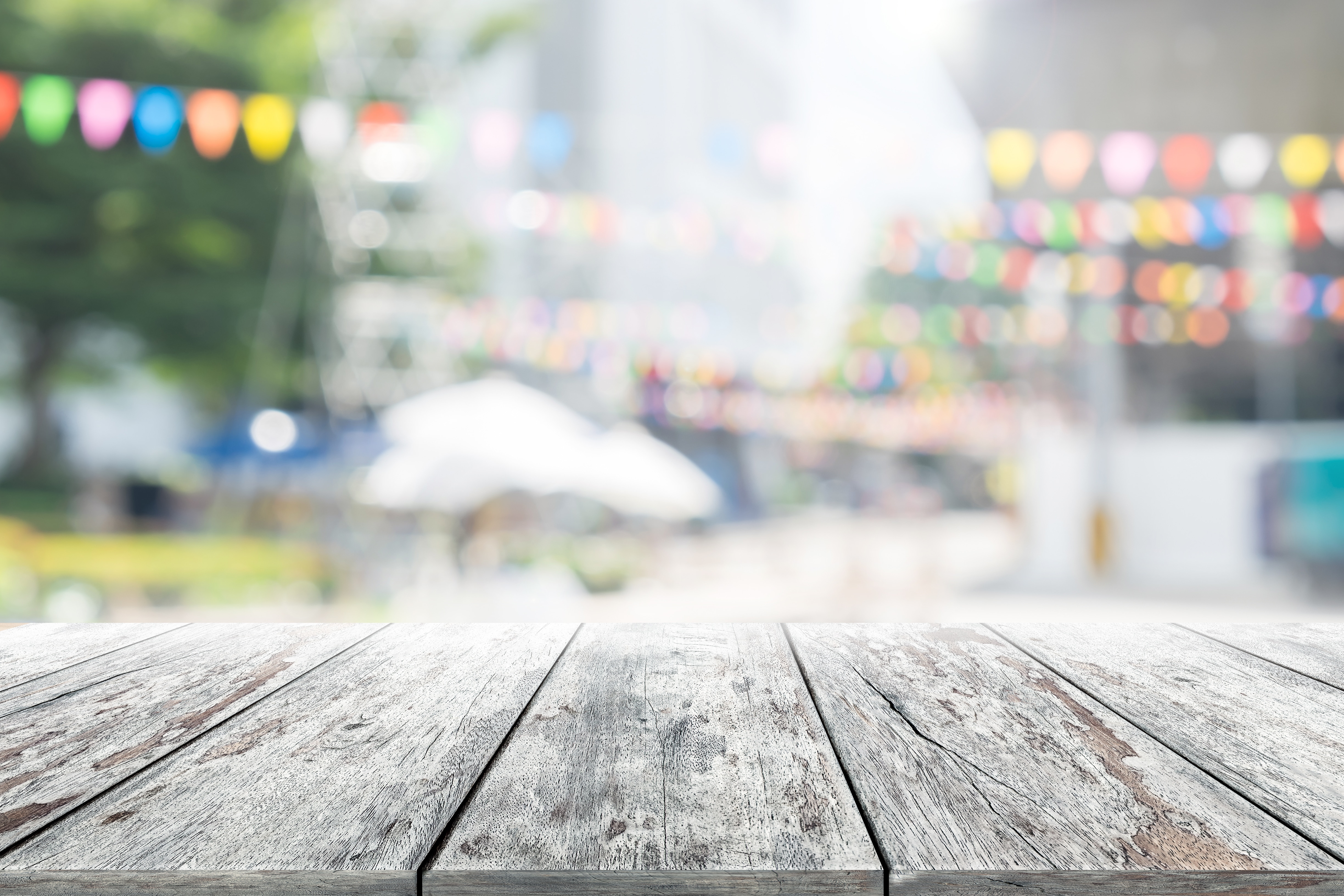 Empty wooden table with party in garden background blurred. - Mag-nificent